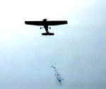 An airplane droping colored paper onto the crowds