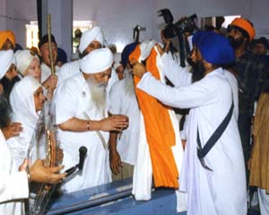 Siri Singh Sahib getting a saropa in Keshghar Sahib from Jethedar Manjit Singh